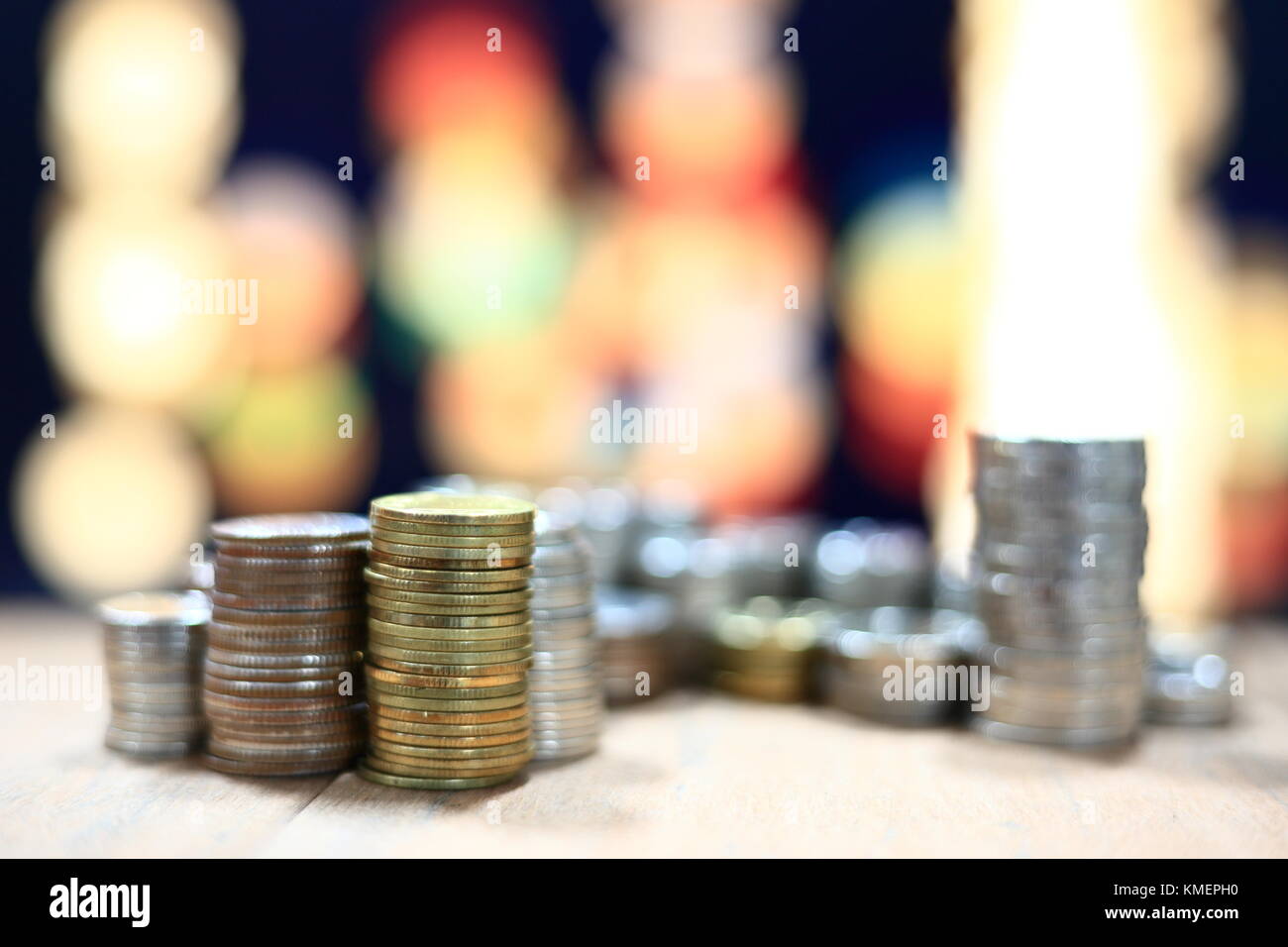 Münze Stapel Stapel auf dem Holztisch und Hintergrund des Lichts bokeh. Innovative Business speichern Konzept. Stockfoto