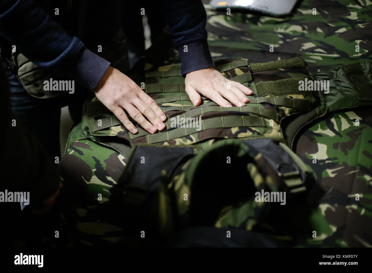 Ein Mann ist der Inspektion eines militärischen Bulletproof Vest Stockfoto