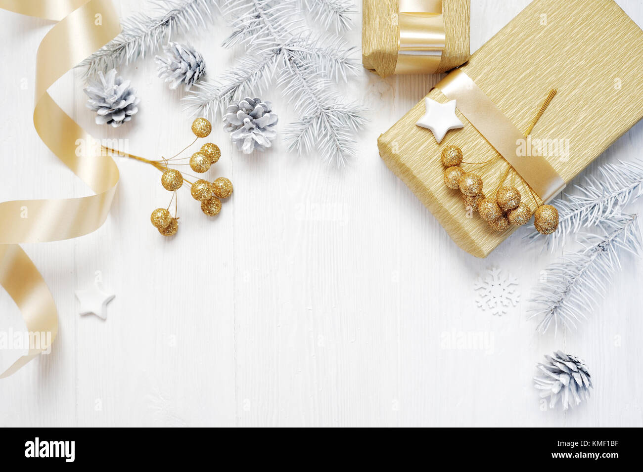 Mockup Weihnachten Geschenk gold Schleifenband und Baum Kegel, flatlay auf einem weißen Hintergrund, aus Holz mit Platz für Ihren Text Stockfoto