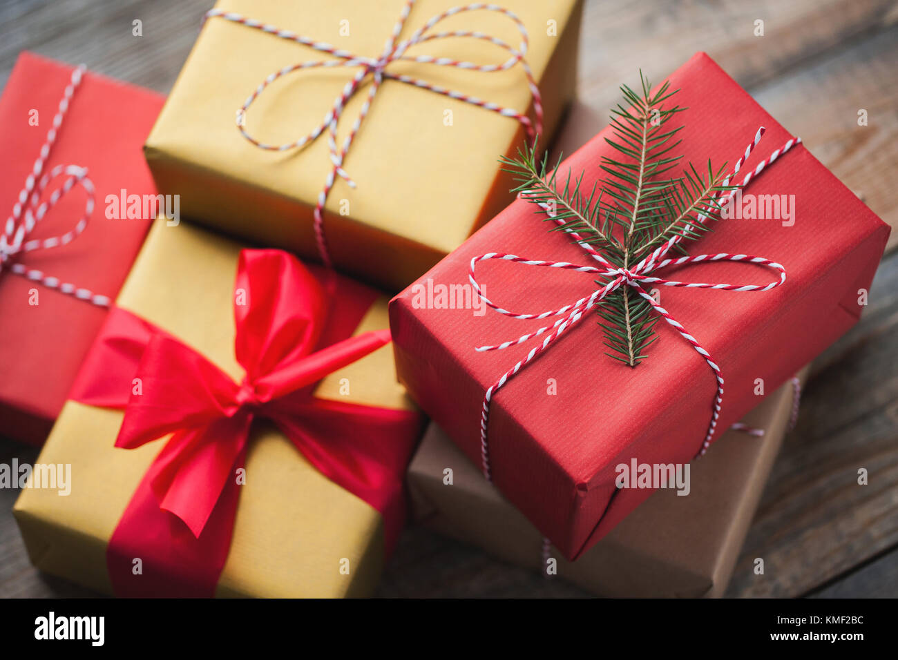 Weihnachtshintergrund mit Geschenkschachteln auf Holzhintergrund. Draufsicht. Schön verpackte, bunte Geschenke für das neue Jahr oder den Tag des Heiligen Stockfoto