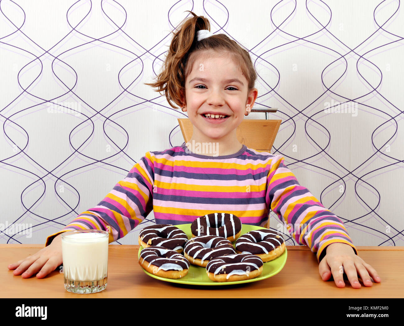 Glückliche kleine Mädchen mit süße Schokolade Donuts Stockfoto