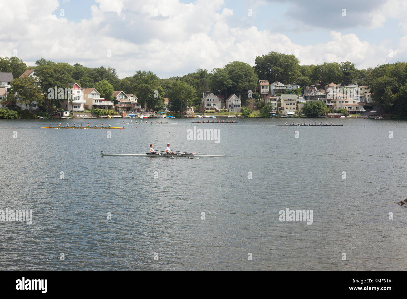 Crew Boote racing in der Regatta auf dem Fluss mit Häusern und Bäumen am Flussufer, Worcester, Massachusetts, USA Stockfoto