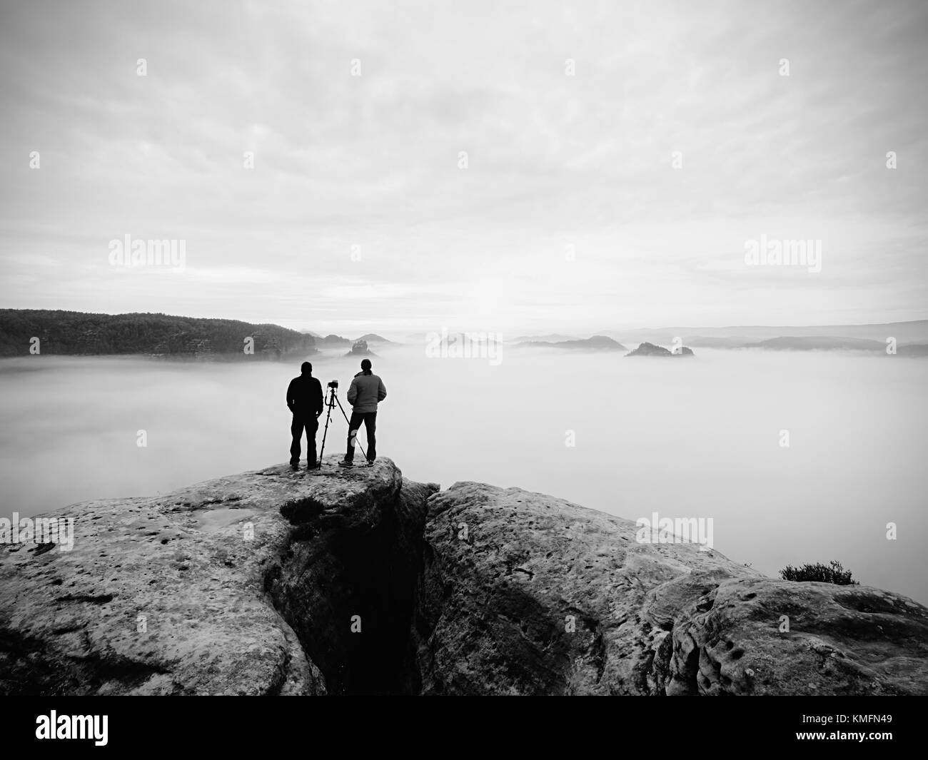 Zwei warmen Mantel Fotografen mit Stativ fotografieren der herbstlichen Landschaft unter Berg. regnerischen nebligen Tag in den Bergen mit bewölkter Himmel, kalt in Stockfoto
