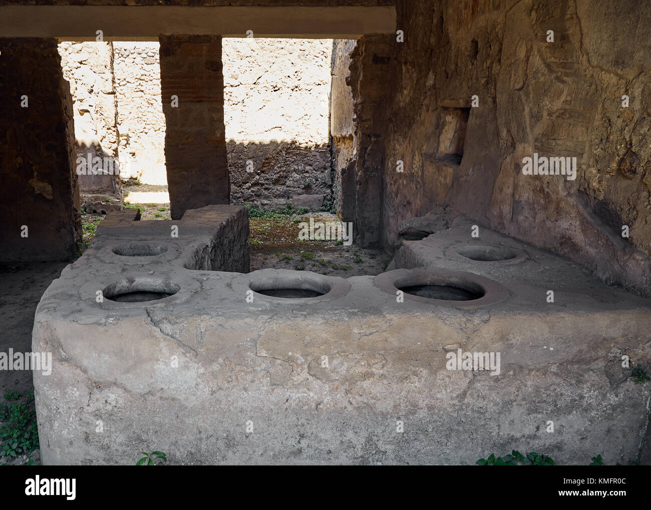 Ruinen der alten Küche in einem der Häuser in Pompeji, Italien. Das Foto zeigt einen alten Backofen mit sechs alten Kochplatten Stockfoto