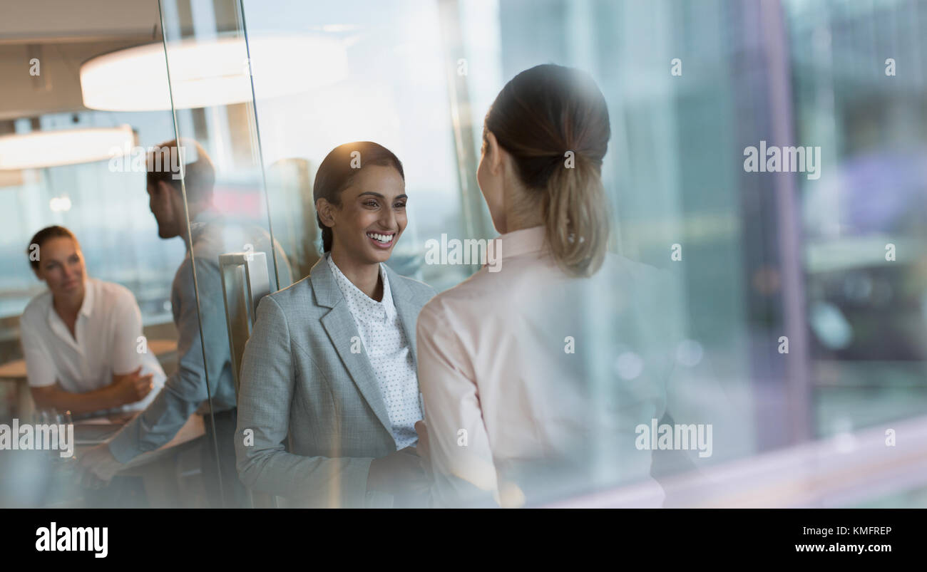 Lächelnde Unternehmerinnen im Gespräch im Büro Stockfoto