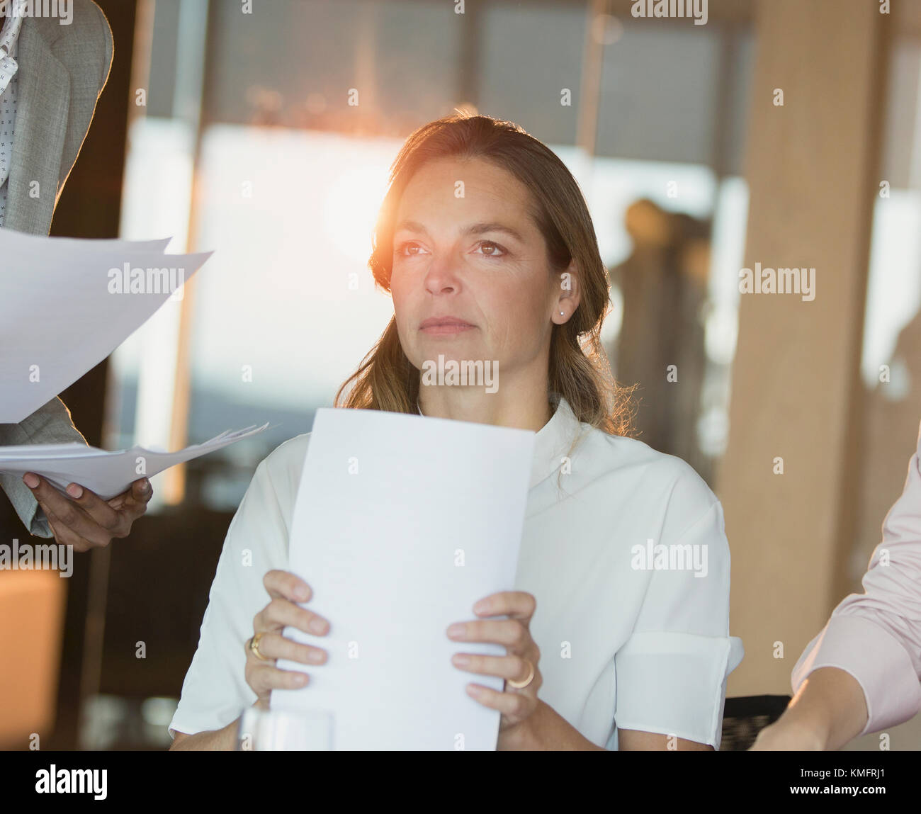Ernsthafte, nachdenkliche Geschäftsfrau mit Schreibarbeit weg schauen im Büro Stockfoto