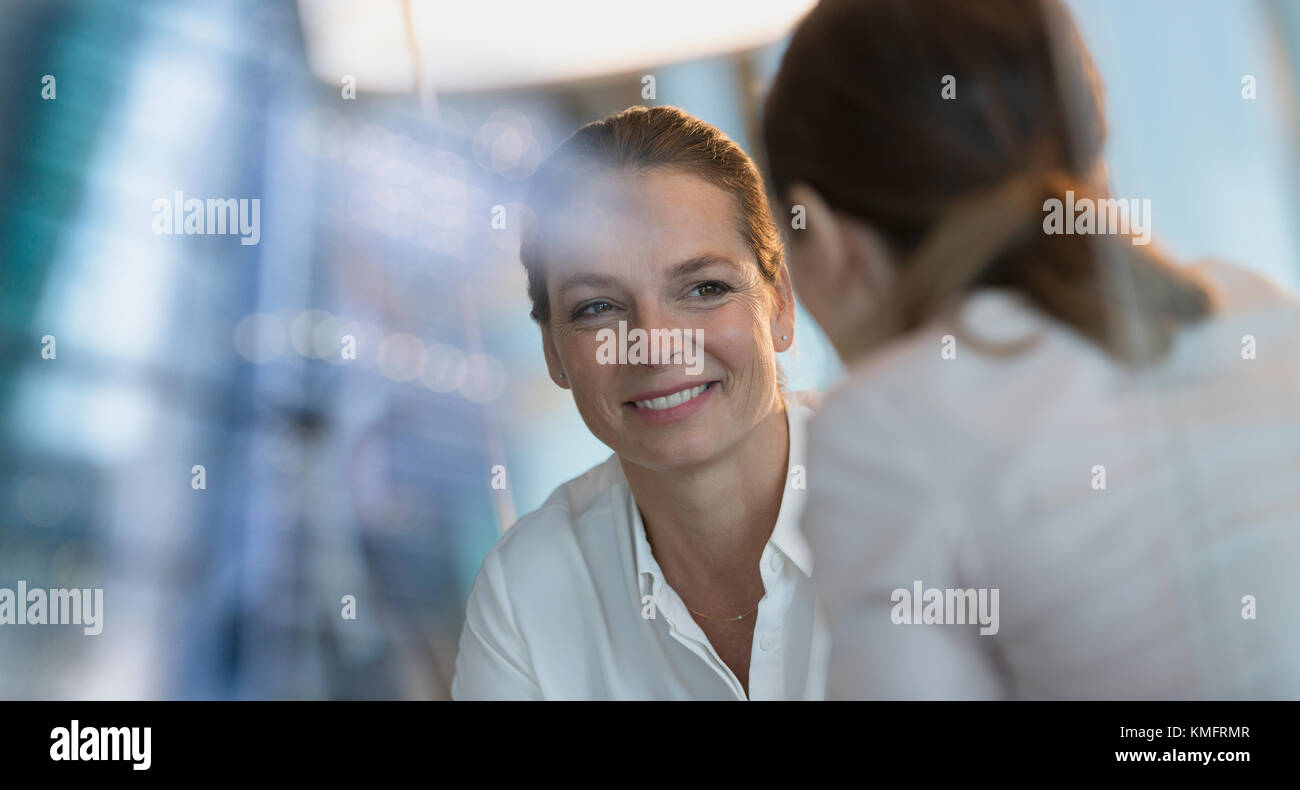 Lächelnd Geschäftsfrau hören zu Kollegen Stockfoto