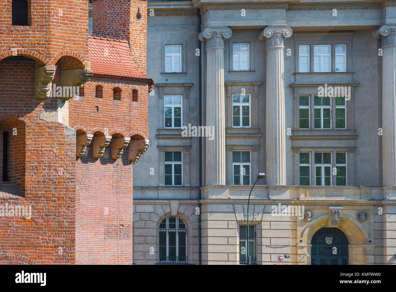Krakau Architektur, die Ostflanke des mittelalterlichen Barbican kontrastiert mit einem neoklassischen Gebäude aus dem 19. Jahrhundert in Krakau, Polen. Stockfoto