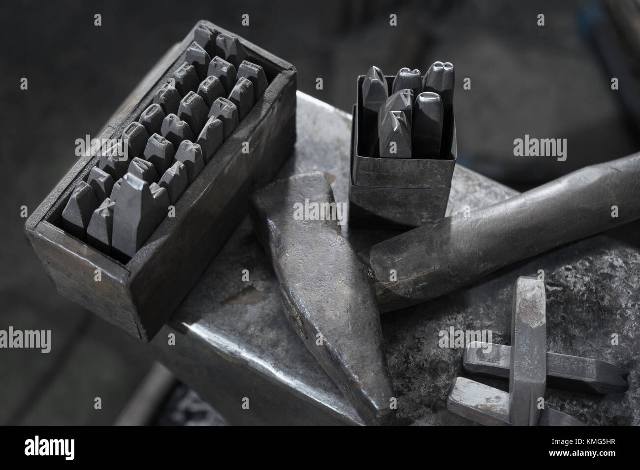 Stanzwerkzeug und Hammer auf Amboss in der Schmiede Stockfoto