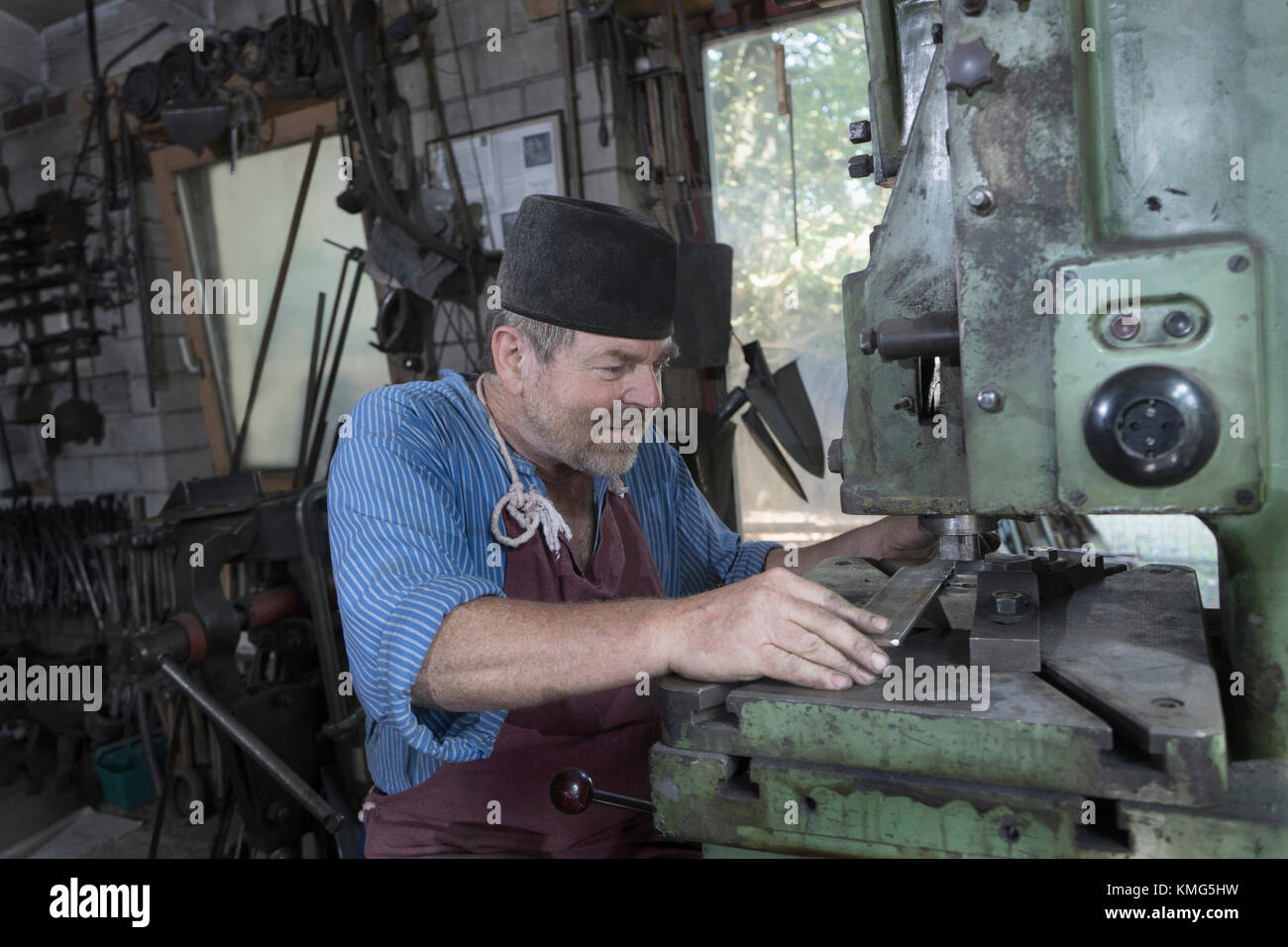 Schmied Stanzen Eisenstange in Maschine in der Werkstatt Stockfoto