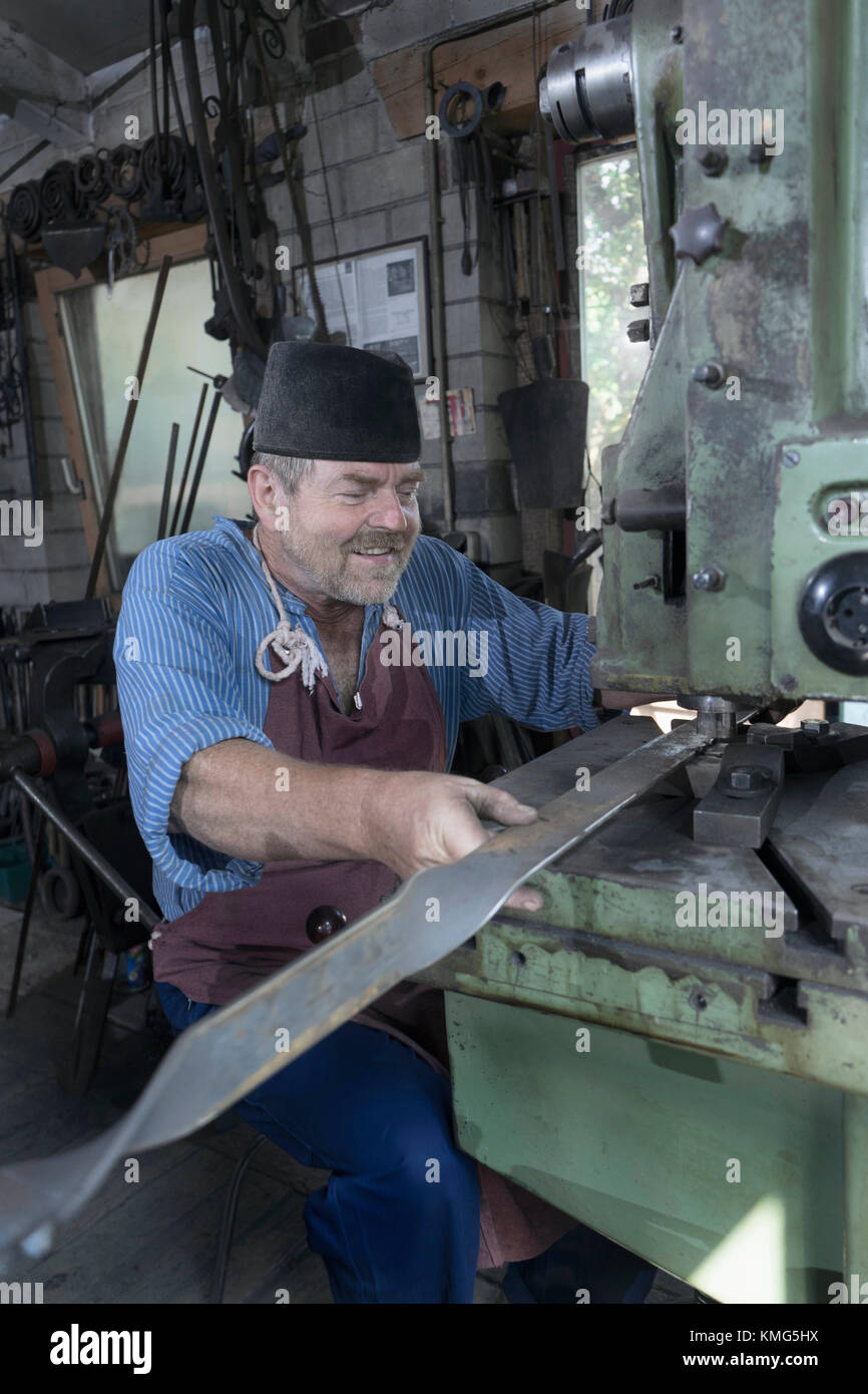 Schmied Stanzen Eisenstange in Maschine in der Werkstatt Stockfoto