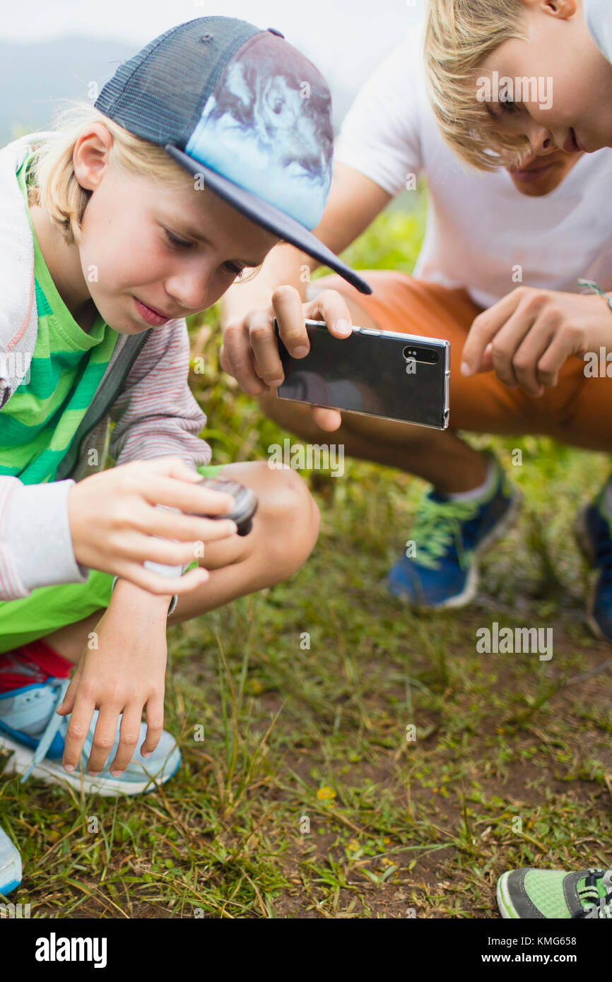 Kinder mit Vater fotografieren Schnecke mit einer mobilen Kamera Stockfoto