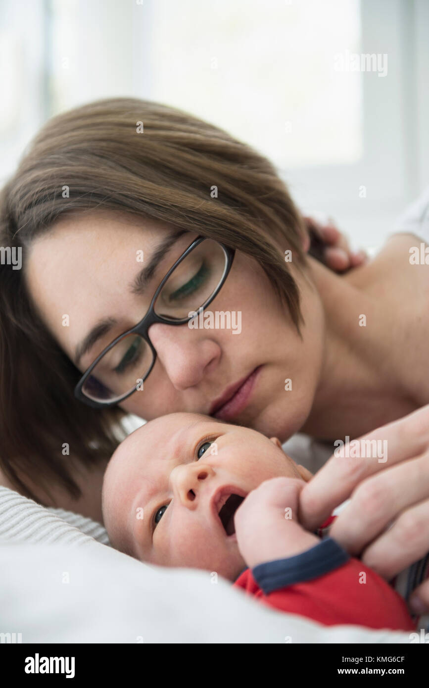 Mutter spielt mit Ihrem neugeborenen Baby auf Bett Stockfoto