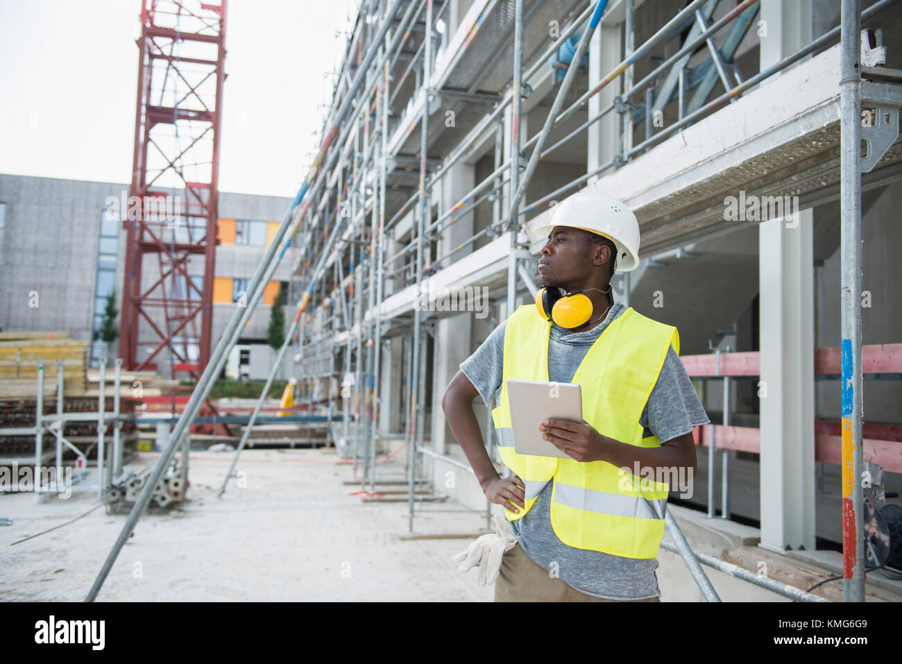 Bauarbeiter hält digitales Tablet auf der Baustelle Stockfoto