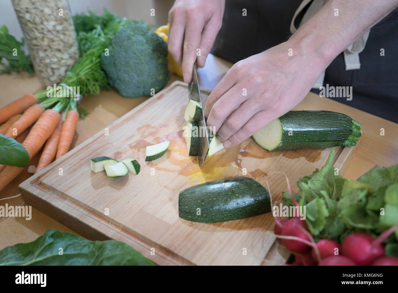Man schneiden Zucchini und Zubereitung von Lebensmitteln Stockfoto