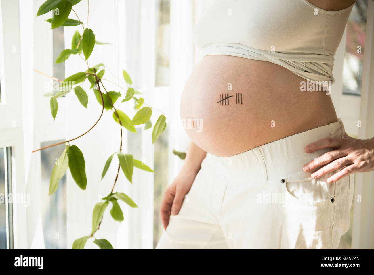 Schwanger Frau mit Tally Chart-Symbol auf dem Bauch Stockfoto