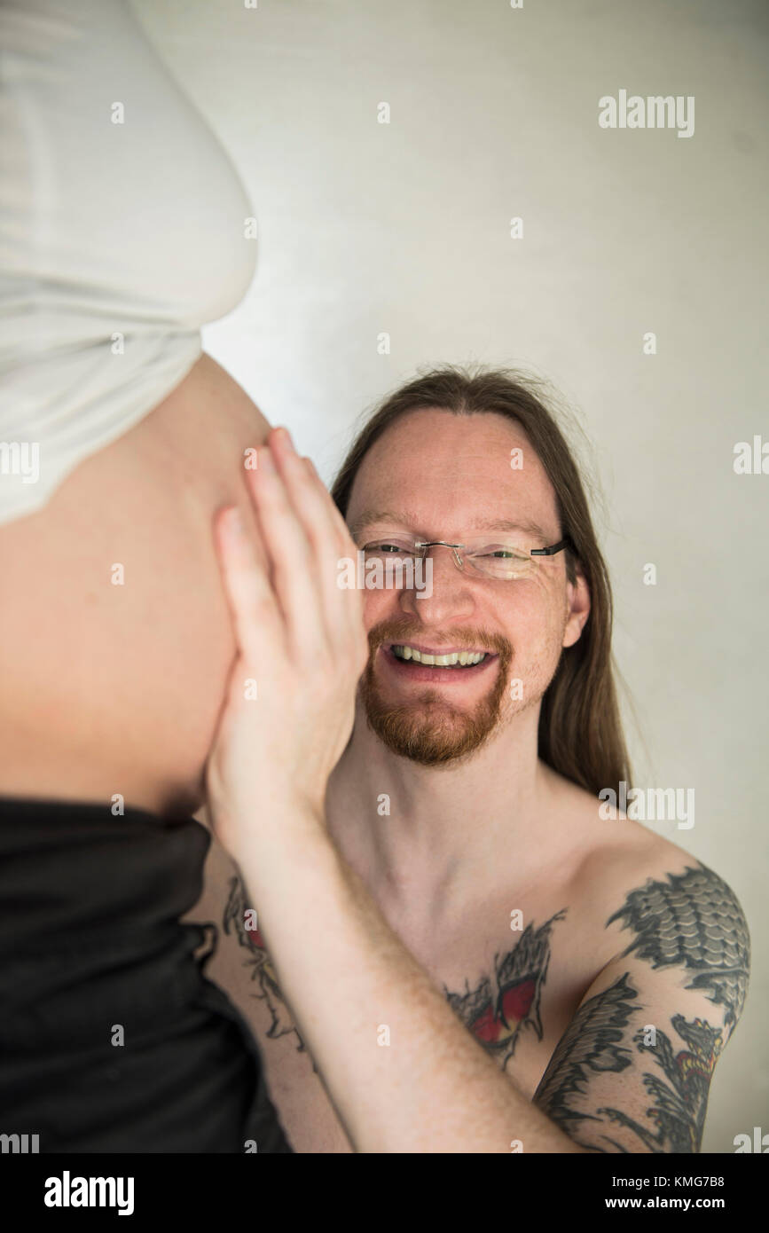 Porträt der Mann die schwangere Frau den Bauch berühren. Stockfoto