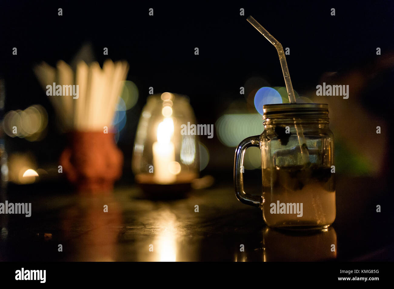 Einen Mojito Drink in einem Becher, Stroh, Papier, Servietten, Glühbirne - alles auf einem Tisch, Blur, Lichter, Bokeh Stockfoto