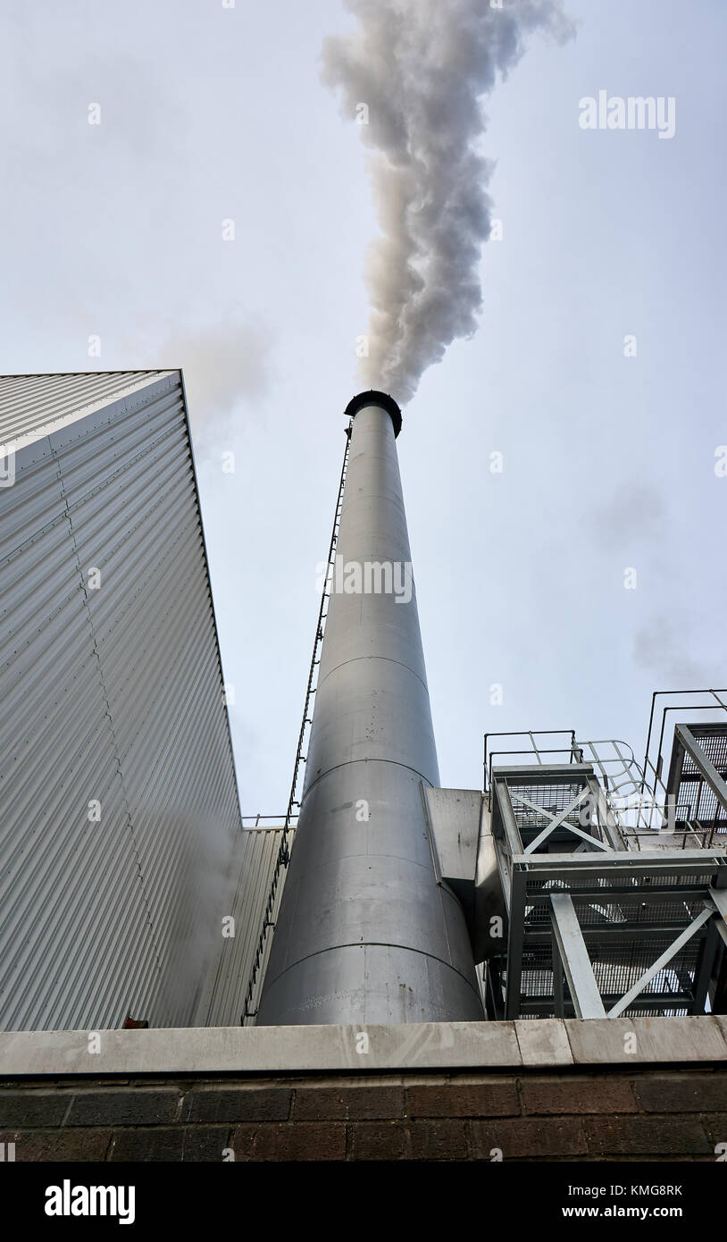 Glasgow, Schottland - 1. Dezember 2017: ein Schornstein von Whiskey Distillery Strathclyde loslassen Dampf und Rauch in der Luft erzeugen die Umweltverschmutzung. Stockfoto