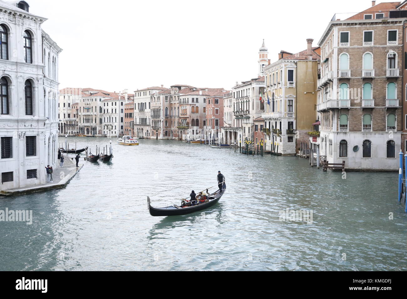 Venedig, Italien: eine Gondel bringt Passagiere entlang des Grand Canal einen Kanal in der Nähe der Ponte di Rialto Brücke in Venedig, Italien. Stockfoto