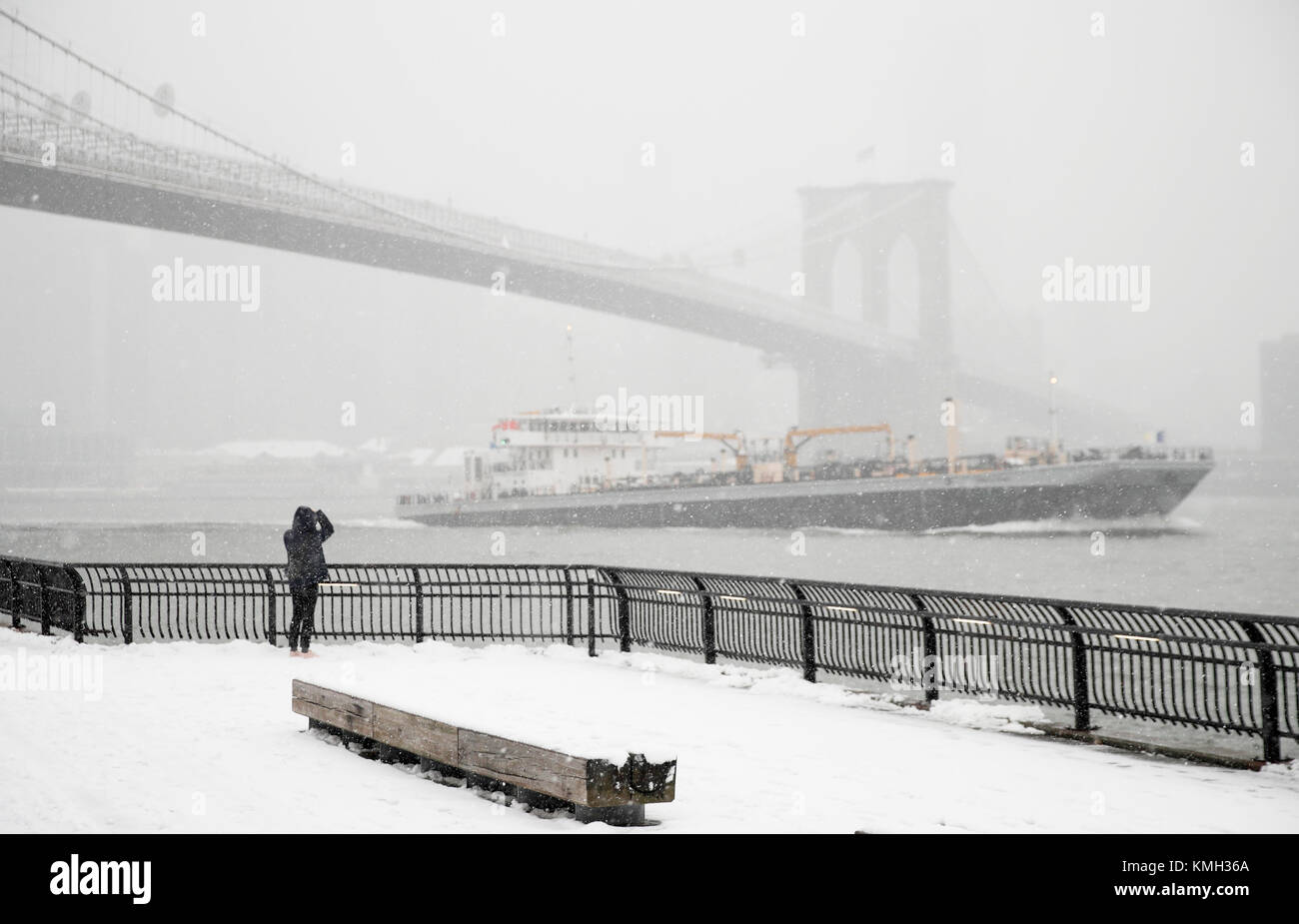 New York, USA. 9 Dez, 2017. Ein Tourist nimmt Foto in der Nähe der Brooklyn Bridge in New York, in den Vereinigten Staaten, Dez. 9, 2017. Der erste Schnee in diesem Winter hits New York am Samstag. Credit: Wang Ying/Xinhua/Alamy leben Nachrichten Stockfoto