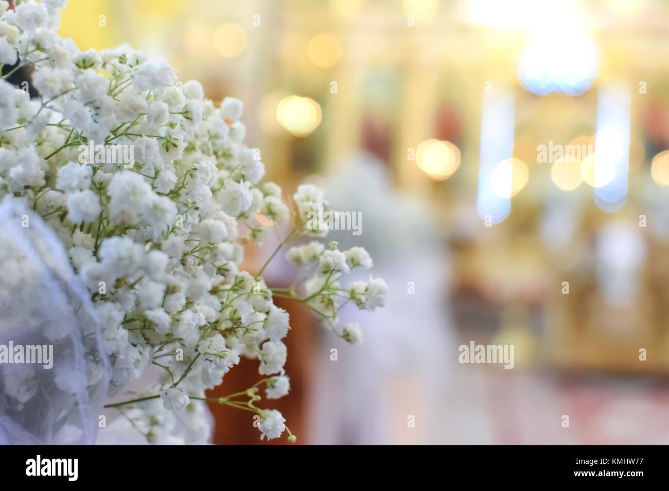 Die Dekoration der Hochzeit Blumen vor dem Hintergrund einer wunderschön unscharfen Kirche Innenraum mit bokeh Effect Stockfoto