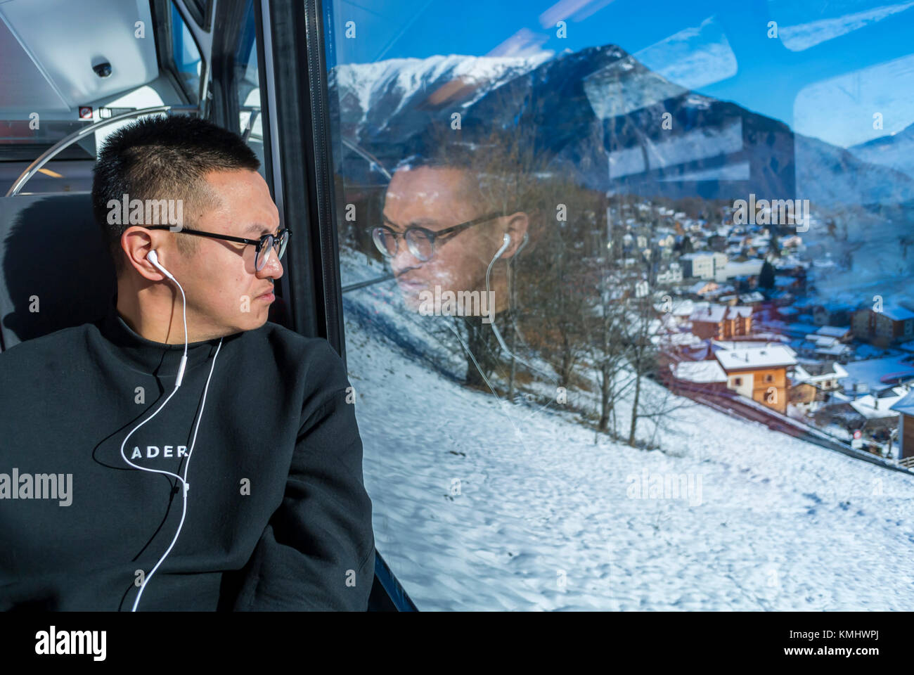 Chamonix-Mont Blanc, Frankreich, Französische Alpen, der chinesischen Touristen zu hören Kopfhörer, inside out watching Fenster auf Zug, Schnee Stockfoto