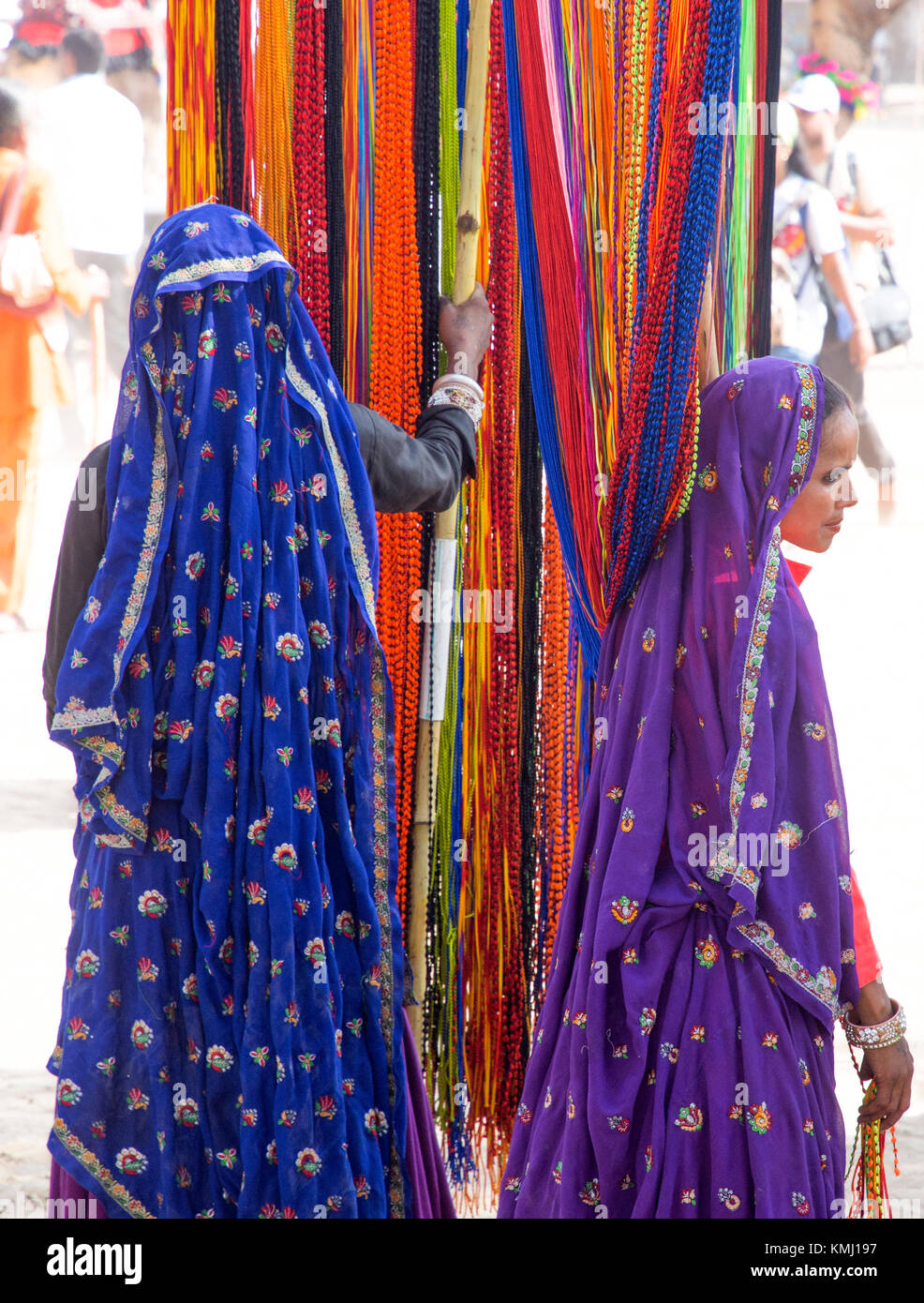 Farbenfroh gekleideten Verkäufer verkaufen lange Strings von Perlen am Pushkar camel Festival in Pushkar, Rajasthan, Indien. Stockfoto