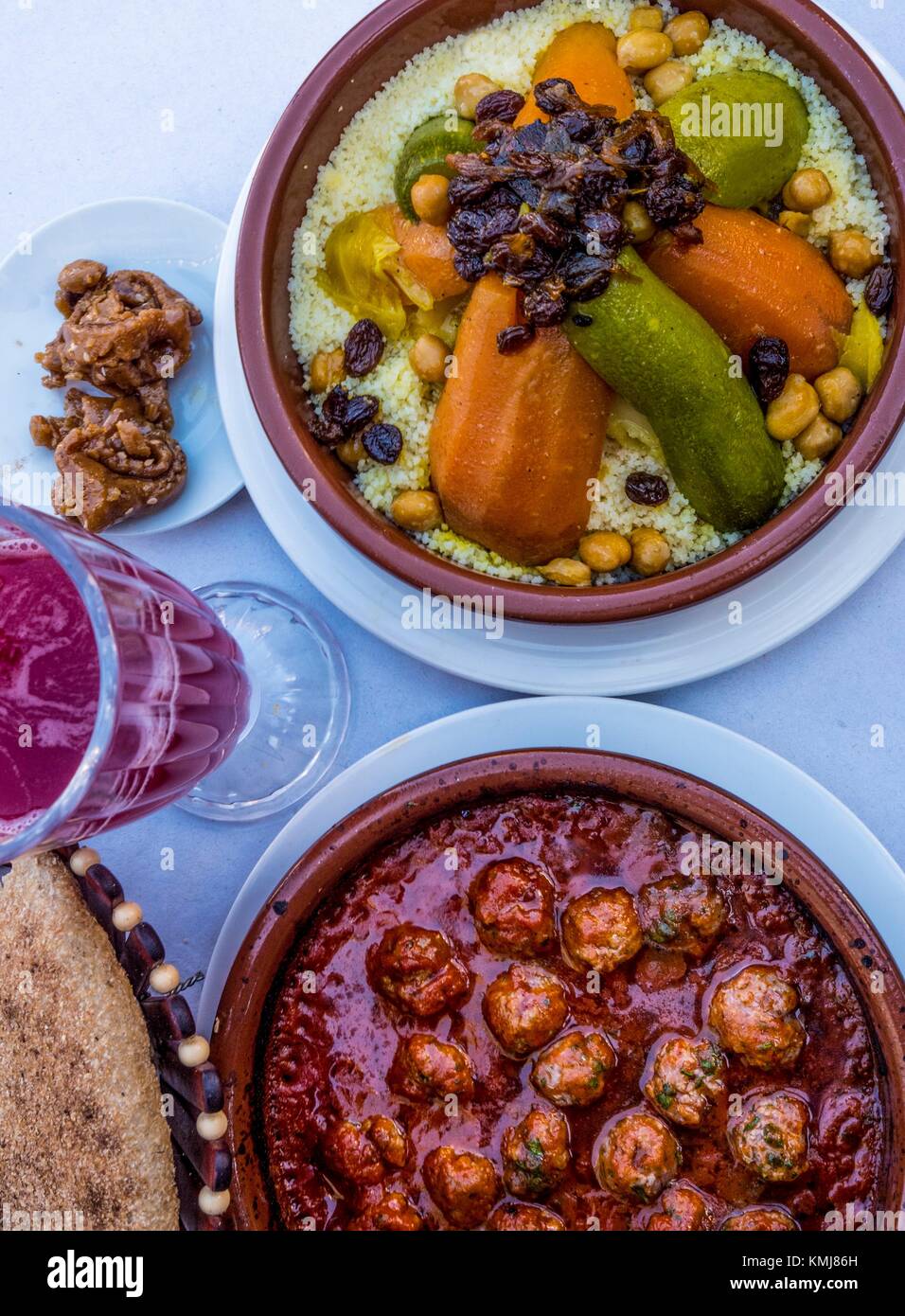 Marokko, das Essen, die 'Kesra' Brot, Granatapfelsaft. 'Chebakia' süße honney Kuchen", Kefta Tagine" (Hackfleisch Kugeln tagine) und "Couscous". Stockfoto