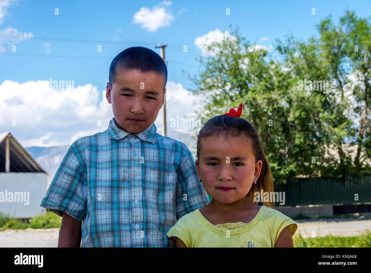 UGUT, Kirgisistan - 16. August: Geschwister, Bruder und eine Schwester mit ernsten Gesichtsausdruck posieren. Ugut ist ein abgelegenes Dorf in Kirgisistan. August 201 Stockfoto