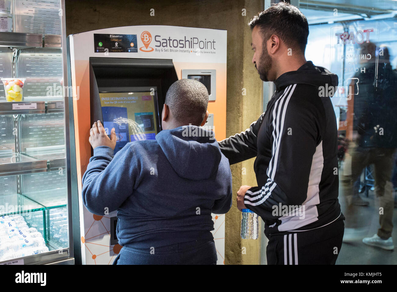 Ein Kunde nutzt eine Bitcoin-Maschine im Londoner U-Bahnhof Old Street, während der unaufhaltsame Aufstieg der Kryptowährung am Donnerstag fortgesetzt wurde, die Marke von£Millionen ( 12,000) überschritten hat und die Angst vor einer gefährlichen Marktblase noch weiter schürte. Stockfoto