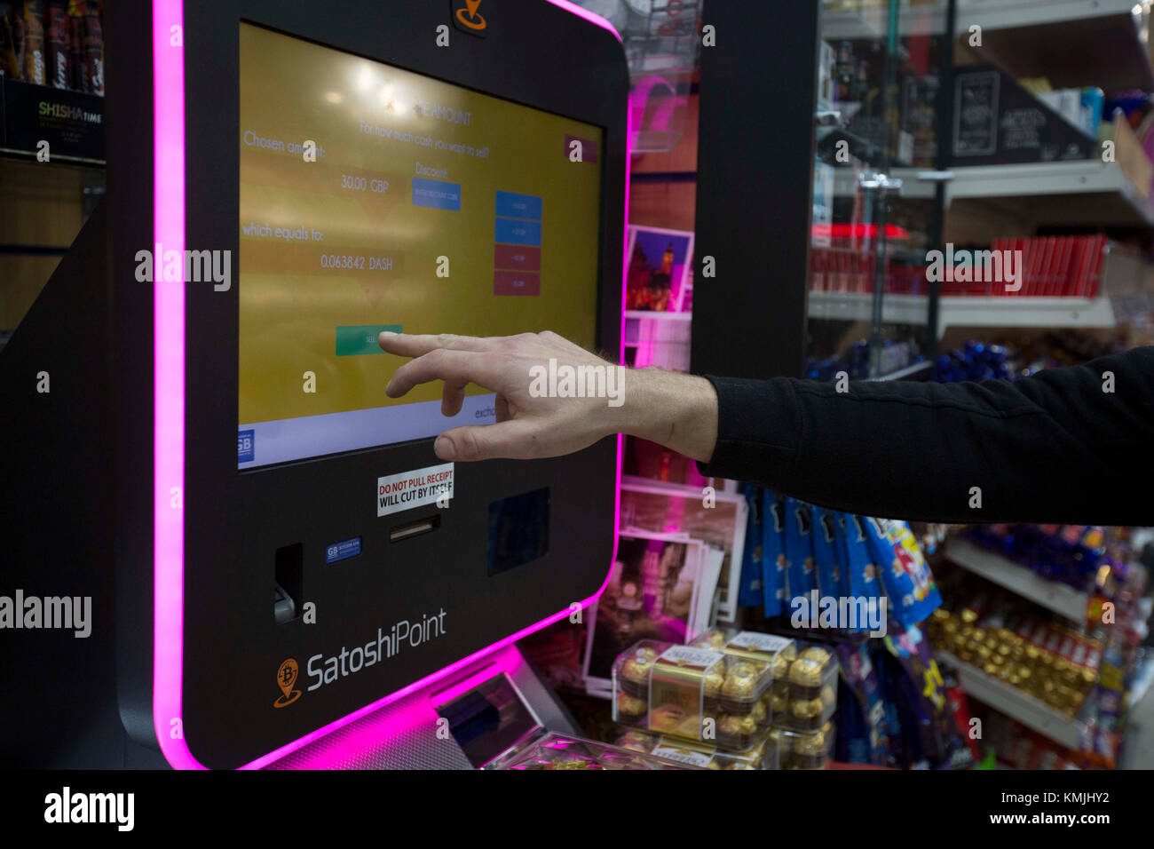 Ein Kunde nutzt eine Bitcoin-Maschine im Piccadilly Circus in London, während der unaufhaltsame Aufstieg der Kryptowährung am Donnerstag fortgesetzt wurde, die Marke von£Millionen ( 12,000) überschritten hat und die Angst vor einer gefährlichen Marktblase noch weiter schürte. Stockfoto