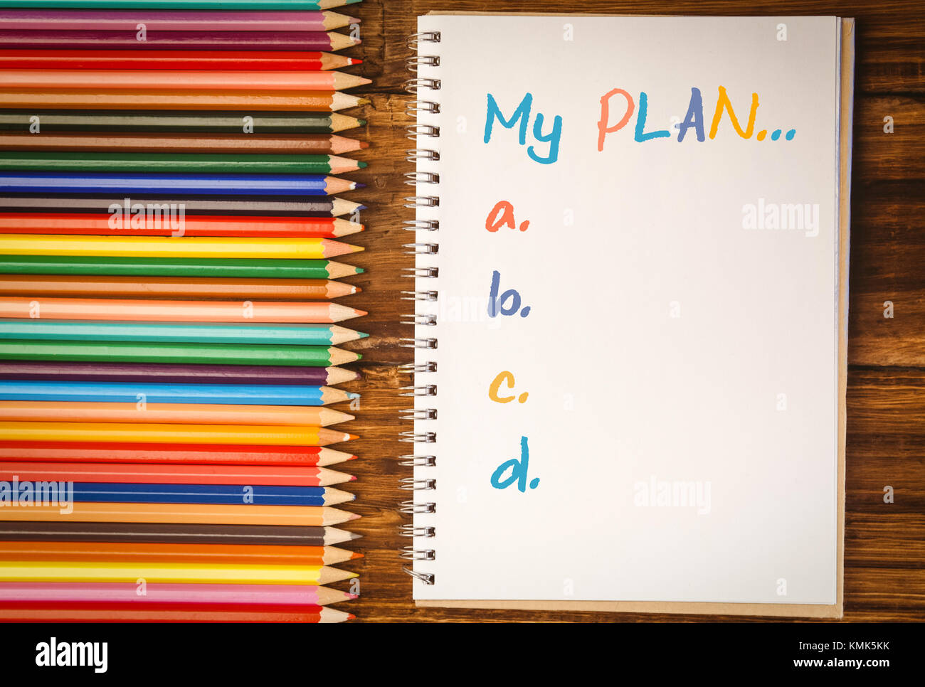 Liste der Plan von a bis e gegen Farbstifte auf dem Schreibtisch mit Notepad Stockfoto
