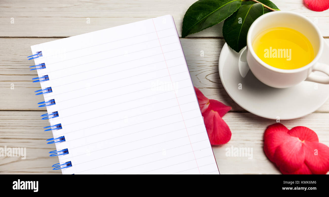Wenig Notepad gegen Tasse Kräutertee am Tisch Stockfoto