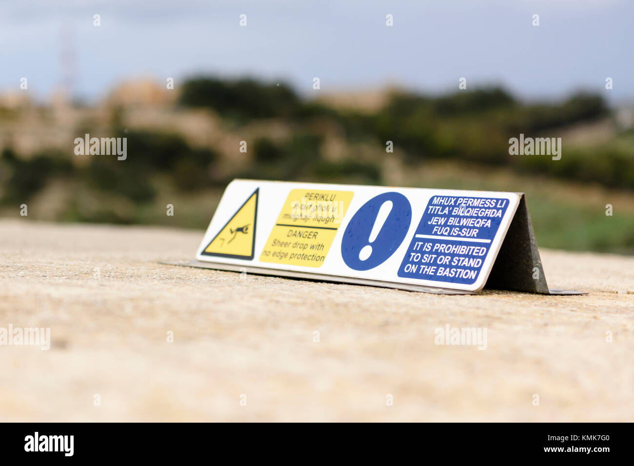 Anmelden Warnung Besucher nicht zu sitzen, auf die Bastion Stadtmauer von Mdina ummauerten Stadt stehen oder, wegen der steil auf der anderen Seite. Stockfoto