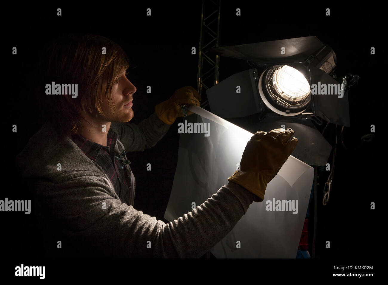 Beleuchtung der Mensch ein Blatt der Diffusor auf ein Studio Licht in ein TV-Studio Stockfoto