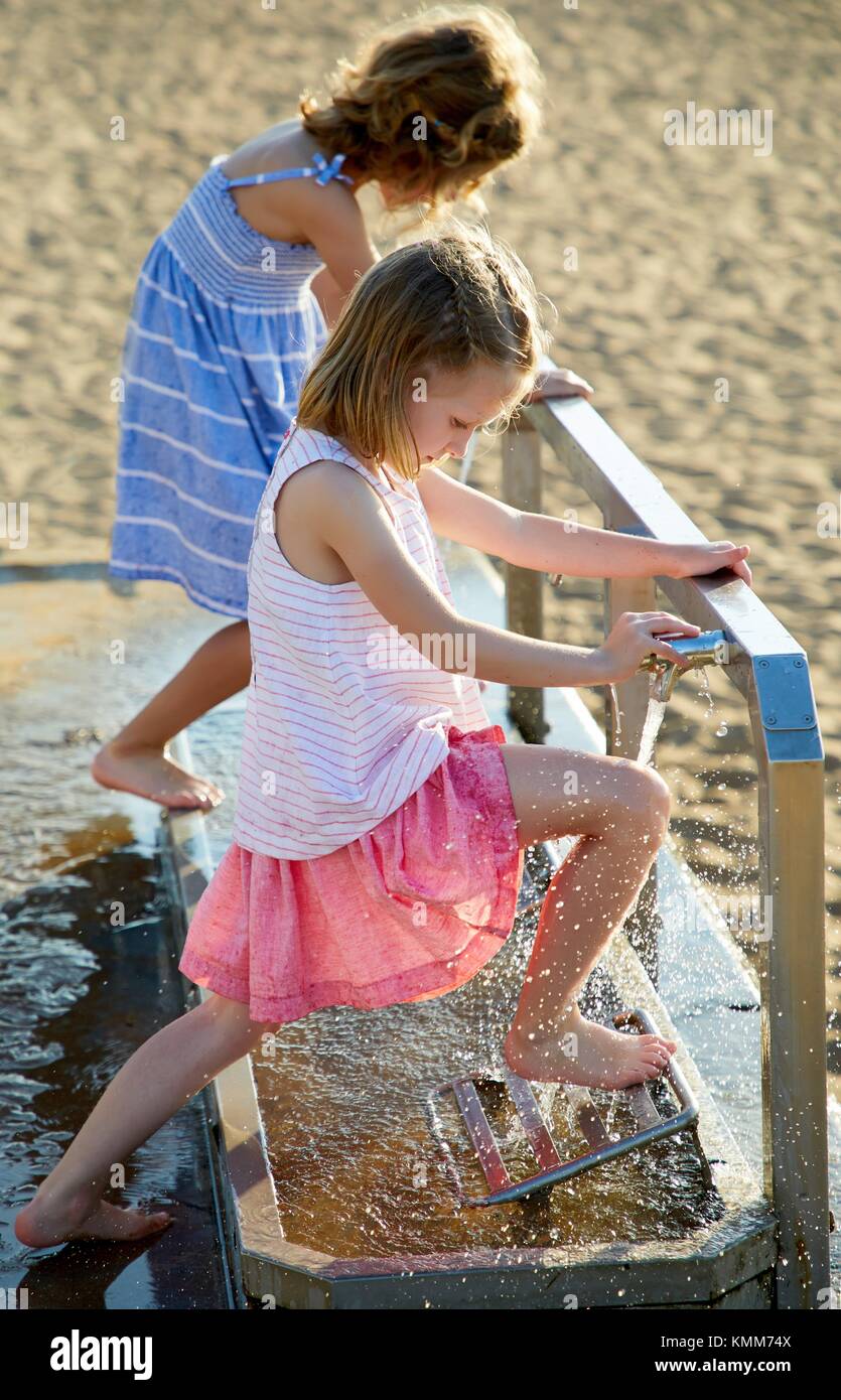 Mädchen wischte ihre Füße am Strand, Zarautz, Gipuzkoa, Baskenland, Spanien, Europa Stockfoto