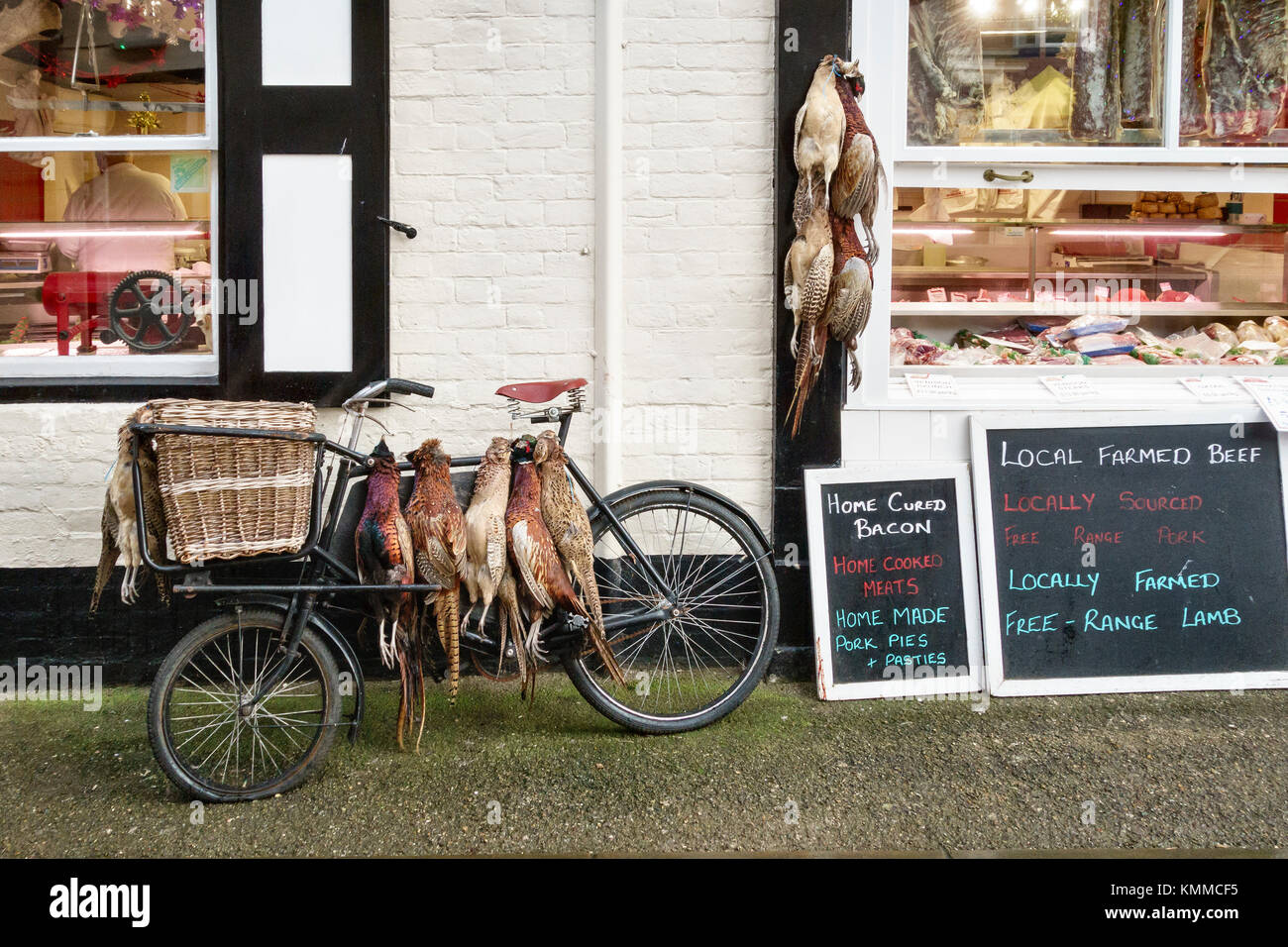 Ludlow, Shropshire, Großbritannien. Fasane hängenden außerhalb einer Auszeichnung der Stadt gewinnen Metzger Läden, bereit für Weihnachten Stockfoto
