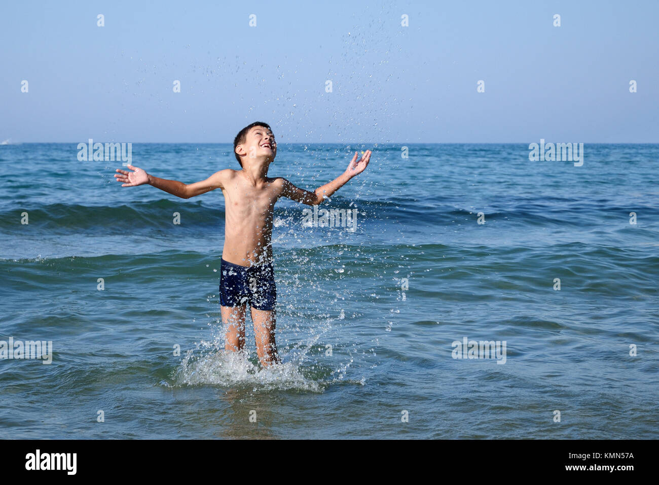 Glückliche junge spielt im Meer Stockfoto