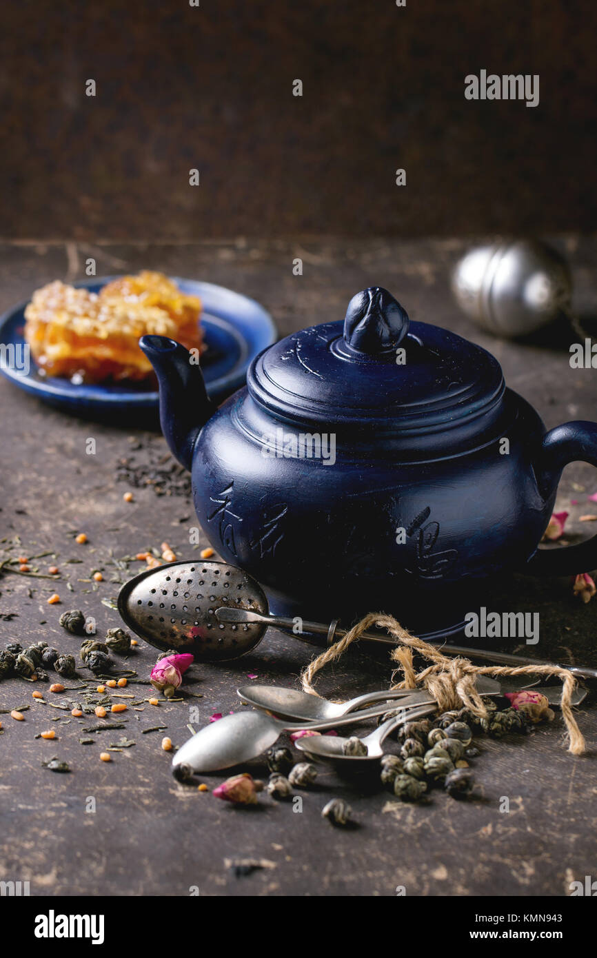 Blau Keramik Teekanne und Platte mit Waben, serviert mit Löffel, schwarzer  und grüner Tee leben in dunklen Hintergrund. Chinesische Inschrift auf  Teekanne-tra Stockfotografie - Alamy