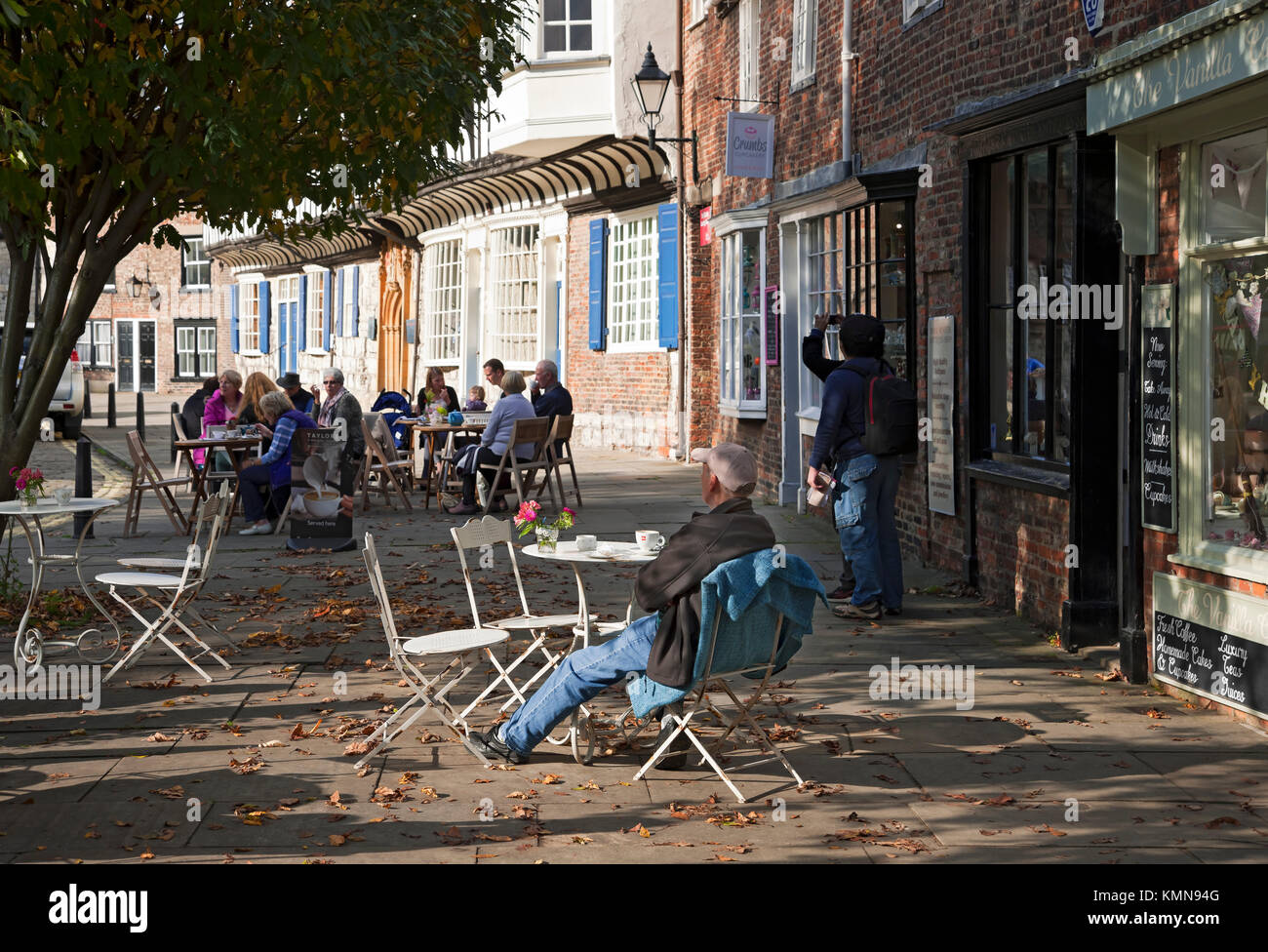 Menschen saßen draußen an Straßencafé-Tischen im Stadtzentrum York North Yorkshire England UK Vereinigtes Königreich GB Großbritannien Stockfoto