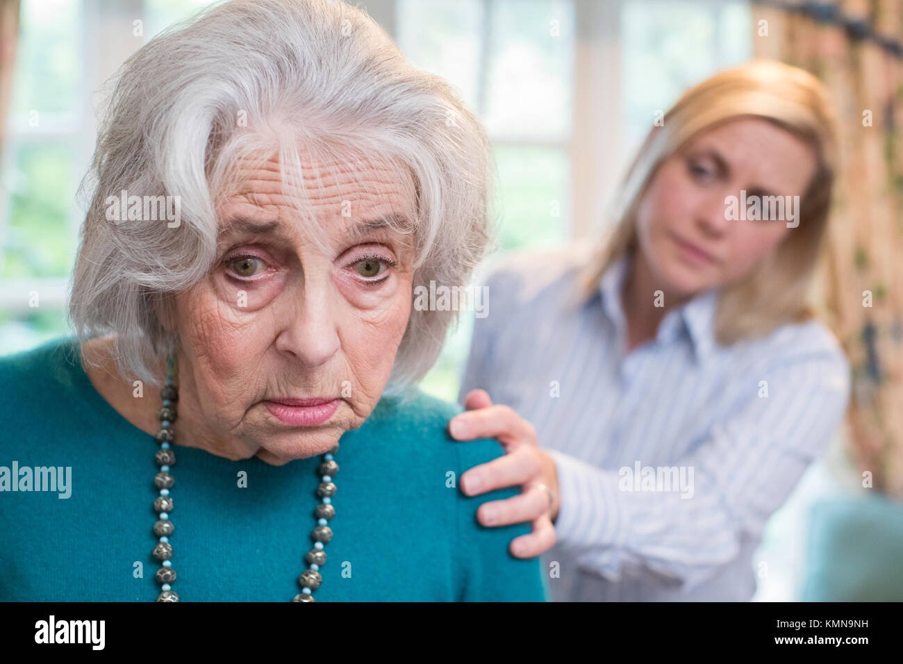 Verwirrte ältere Frau mit erwachsenen Tochter zu Hause Stockfoto