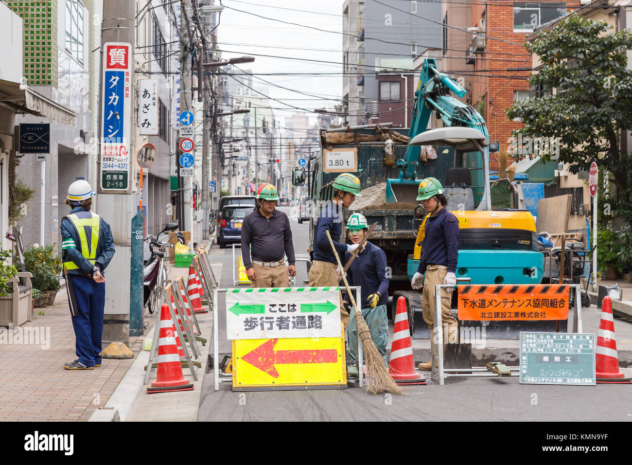 Tokio, Japan - 7. August 2023 : japanische Arbeiter sperren die Straße für Arbeiten und Reparaturen an Straßenschäden, Infrastruktur und Bauindustrie Stockfoto