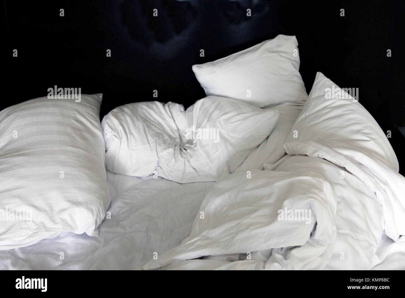 Bett morgens nach der Nacht mit vielen chaotisch Kissen und Bettlaken Stockfoto