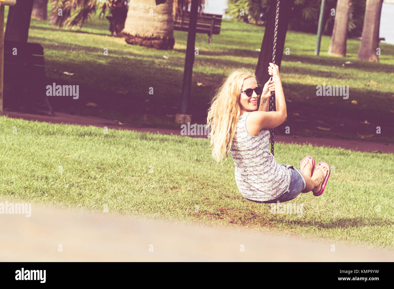 Ein netter Spaß Mädchen im Park, mit einem Schwingen. Stockfoto