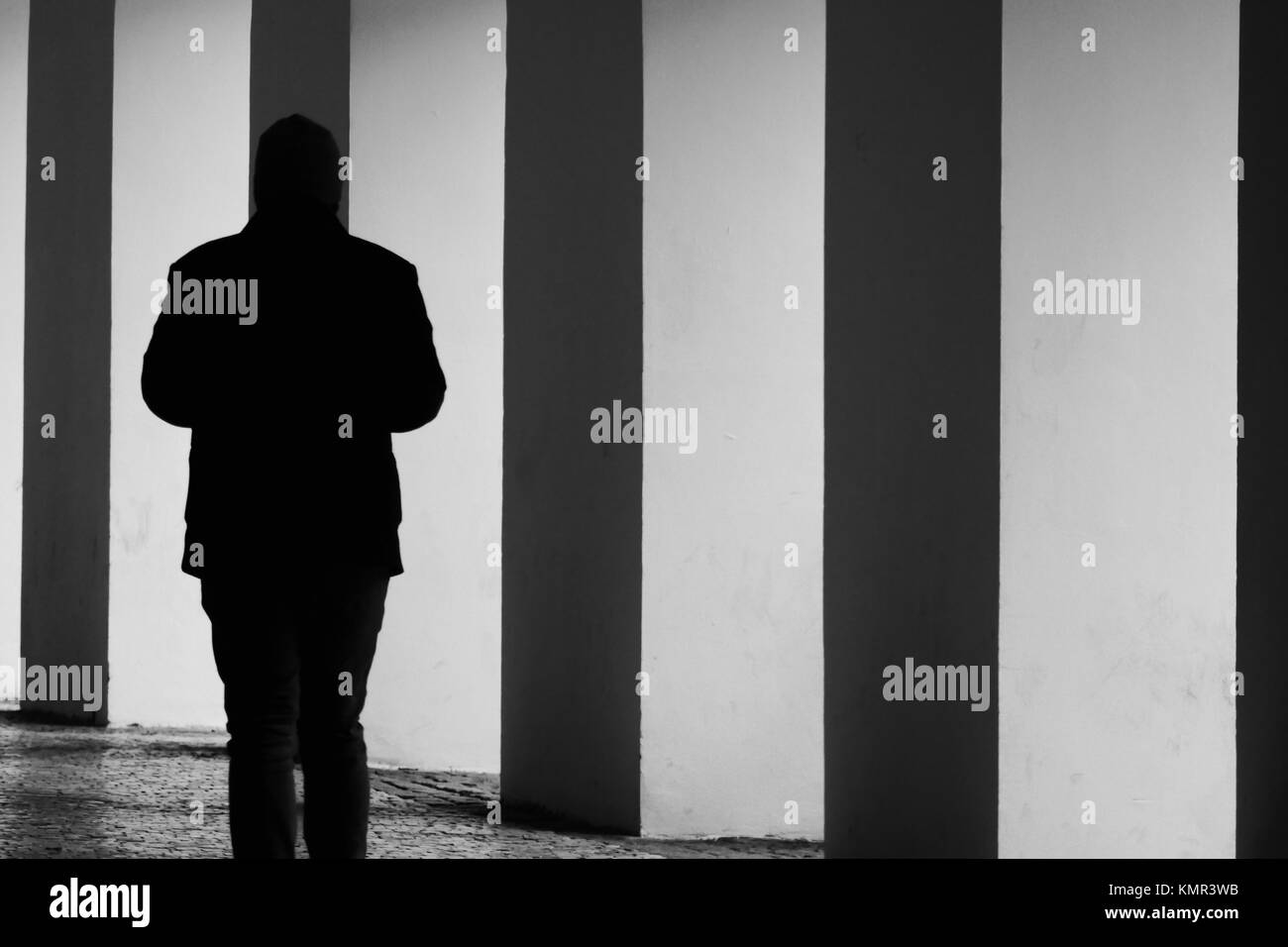 Silhouette eines Mannes vorbei Bögen in einer Seitenstraße an einem kalten November Tag in der historischen Stadt Prag. Stockfoto