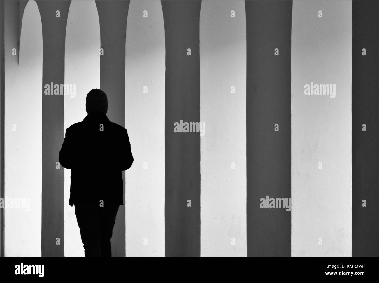 Silhouette eines Mannes vorbei Bögen in einer Seitenstraße an einem kalten November Tag in der historischen Stadt Prag. Stockfoto