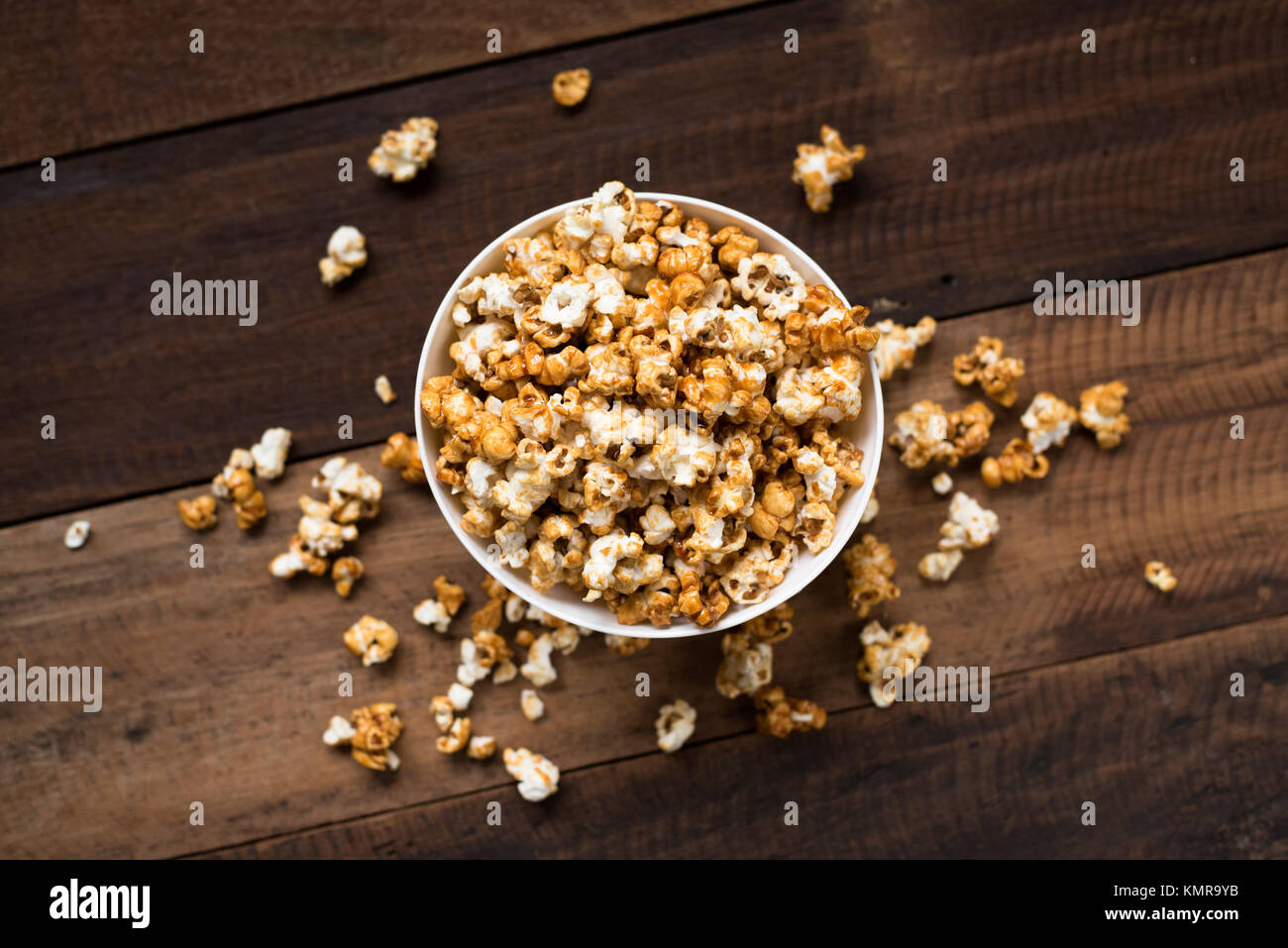 Karamell Popcorn auf hölzernen Tisch Hintergrund. Karamell aromatisierter Popcorn in der Schüssel Stockfoto