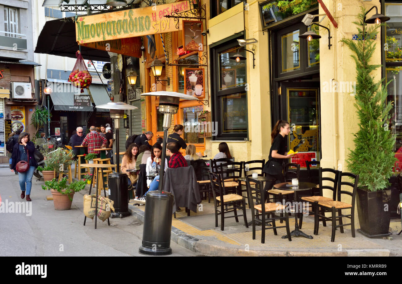 Zwei Restaurants, beide mit Tischen und Stühlen auf Pflaster außen mit Kunden, Athen, Griechenland. Stockfoto