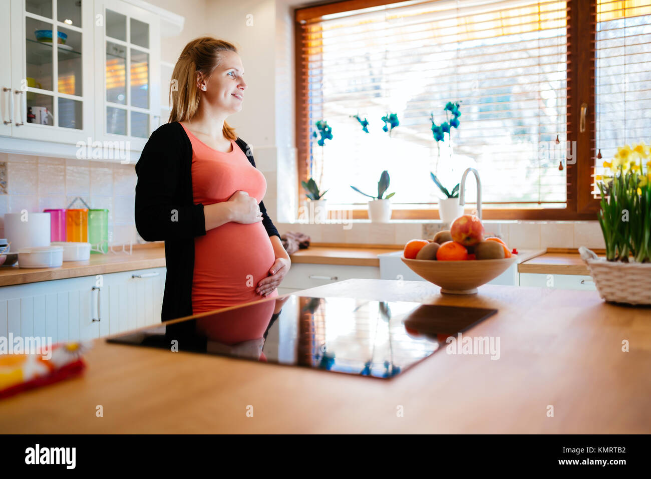 Schöne schwangere Frau ki Küche Stockfoto
